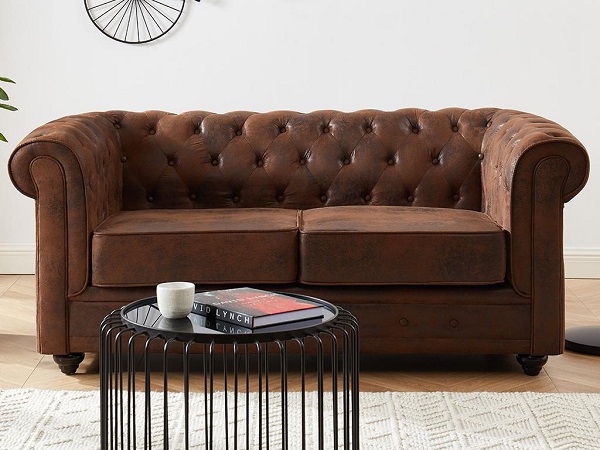 Canapé double Chesterfield à louer, avec un aspect cuir vieilli offrant une touche vintage et un style intemporel lors de vos événements spéciaux.