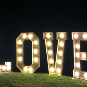 Location de lettres en bois géantes L.O.V.E avec ampoule. Idéale pour une ambiance chaleureuse et romantique à votre événement.
